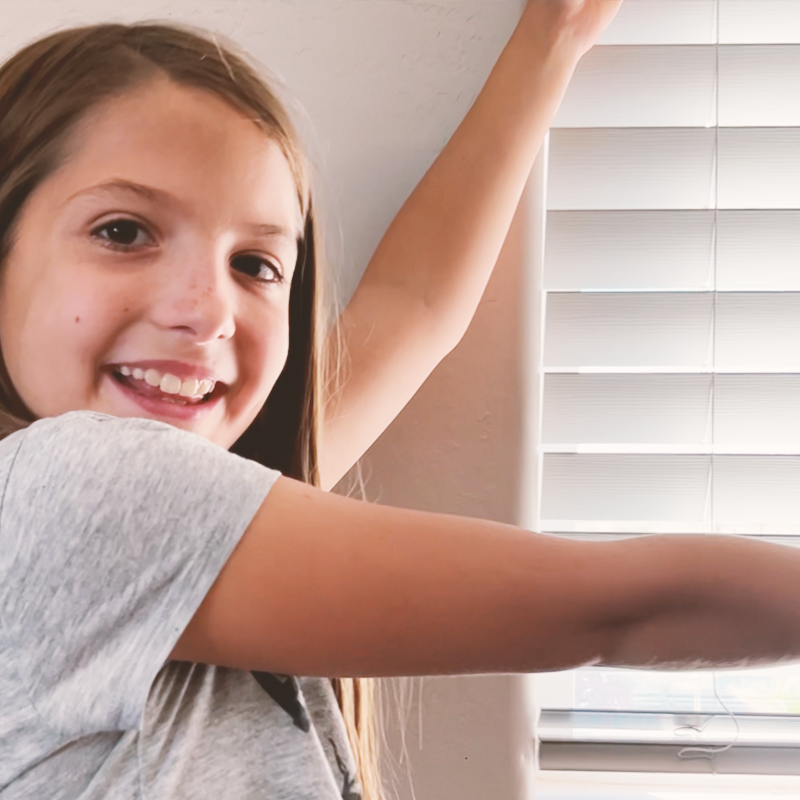 Child showing her blinds that she installed.