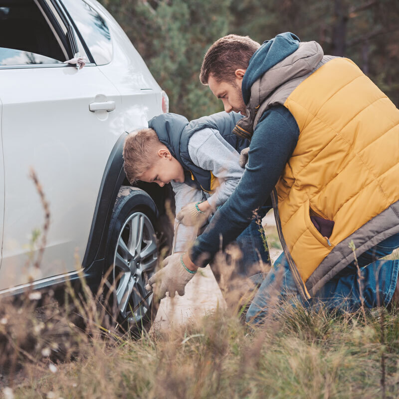 Father and son changing a flat tire